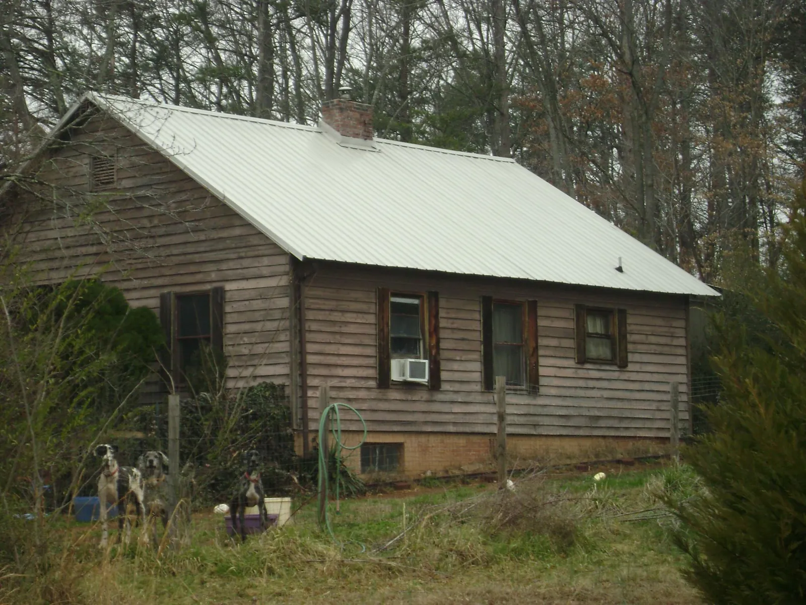 White metal roof on an old wood sided farmhouse, from a Metal Roof Installation job in Owasso